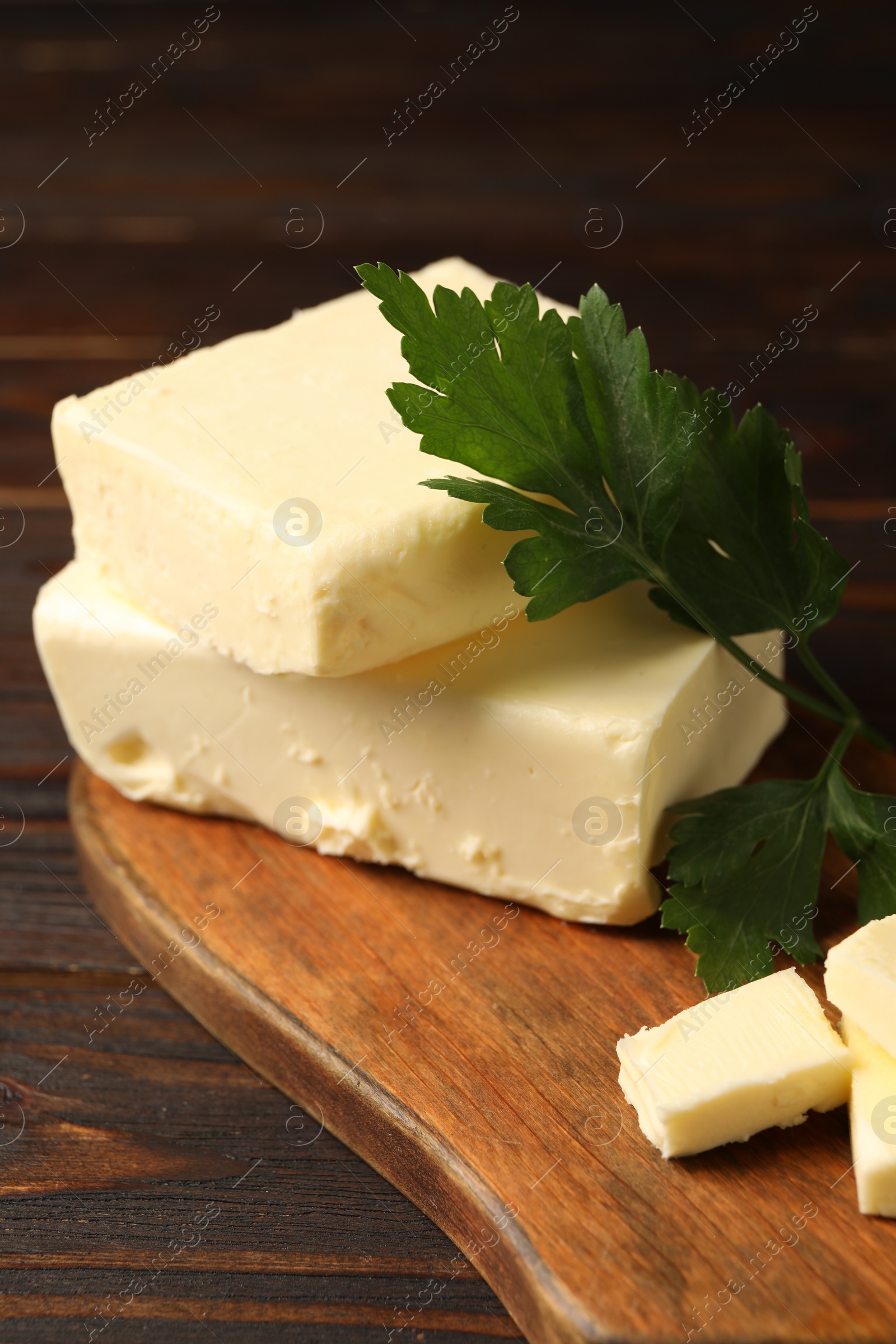 Photo of Tasty butter and parsley on wooden table, closeup