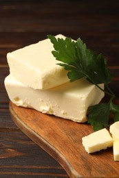 Tasty butter and parsley on wooden table, closeup