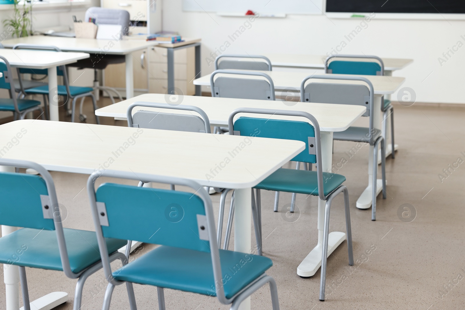 Photo of Empty school classroom with desks and chairs