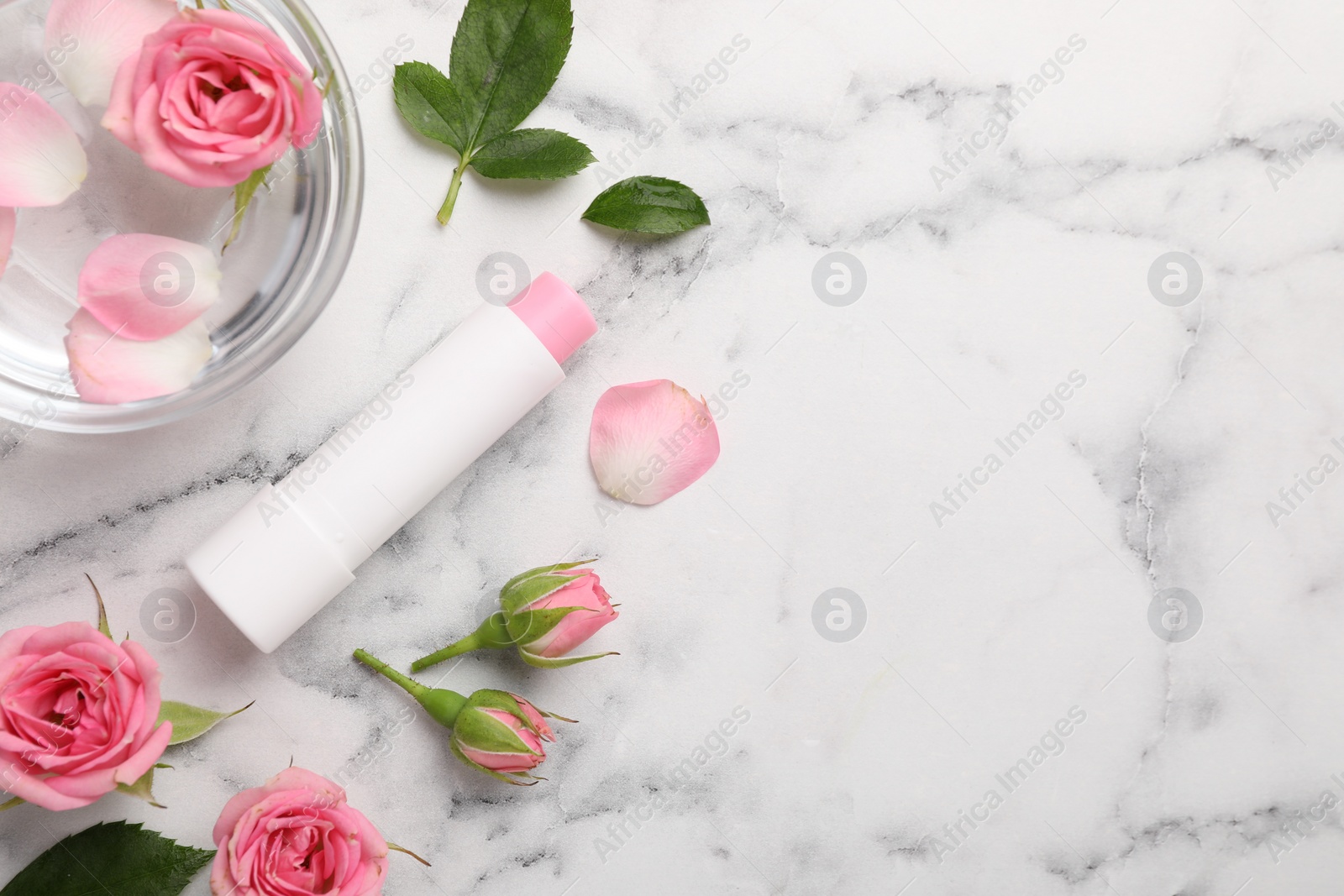 Photo of Flat lay composition with lip balm on white marble background, space for text