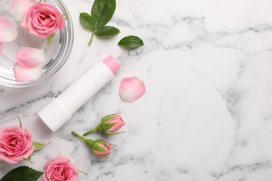 Flat lay composition with lip balm on white marble background, space for text