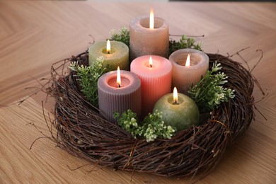 Photo of Beautiful composition with burning candles on wooden table, closeup