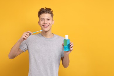 Photo of Young man with mouthwash and toothbrush on yellow background