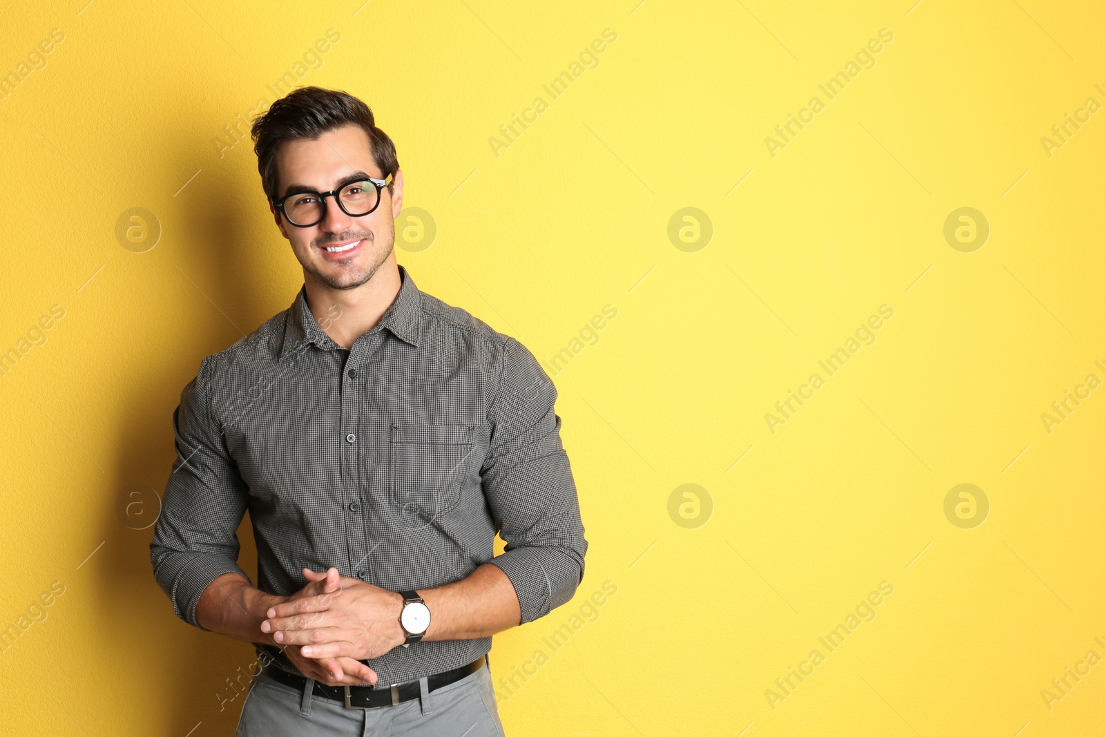 Photo of Young man with glasses on yellow background. Space for text