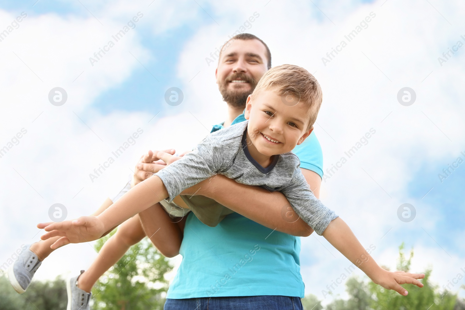 Photo of Man playing with his child outdoors. Happy family