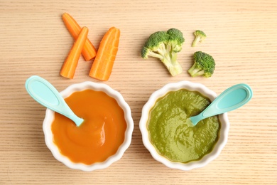 Photo of Flat lay composition with healthy baby food and ingredients on wooden table