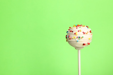 Photo of Bright delicious cake pop on color background. Space for text