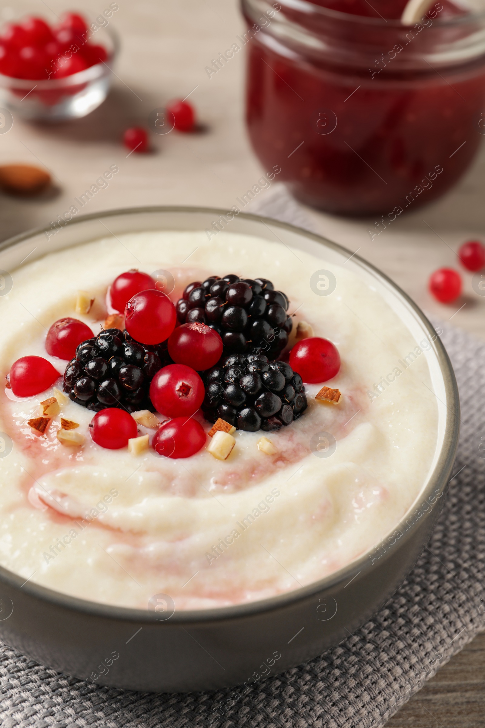 Photo of Delicious semolina pudding with berries on wooden table