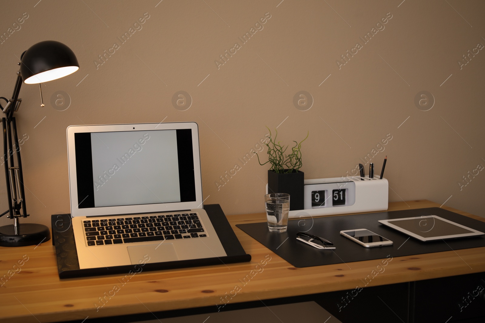 Photo of Modern workplace interior with laptop and devices on table. Space for text