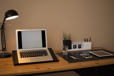 Modern workplace interior with laptop and devices on table. Space for text