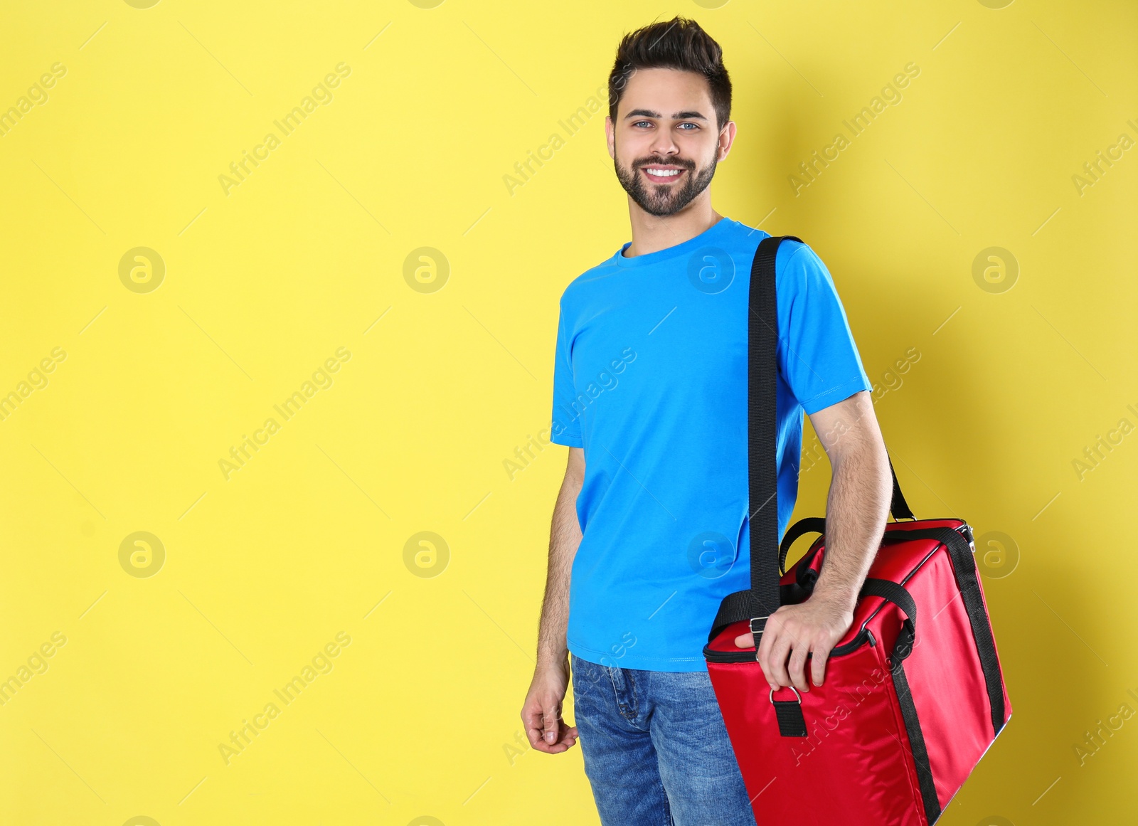 Photo of Courier with thermo bag on yellow background, space for text. Food delivery service