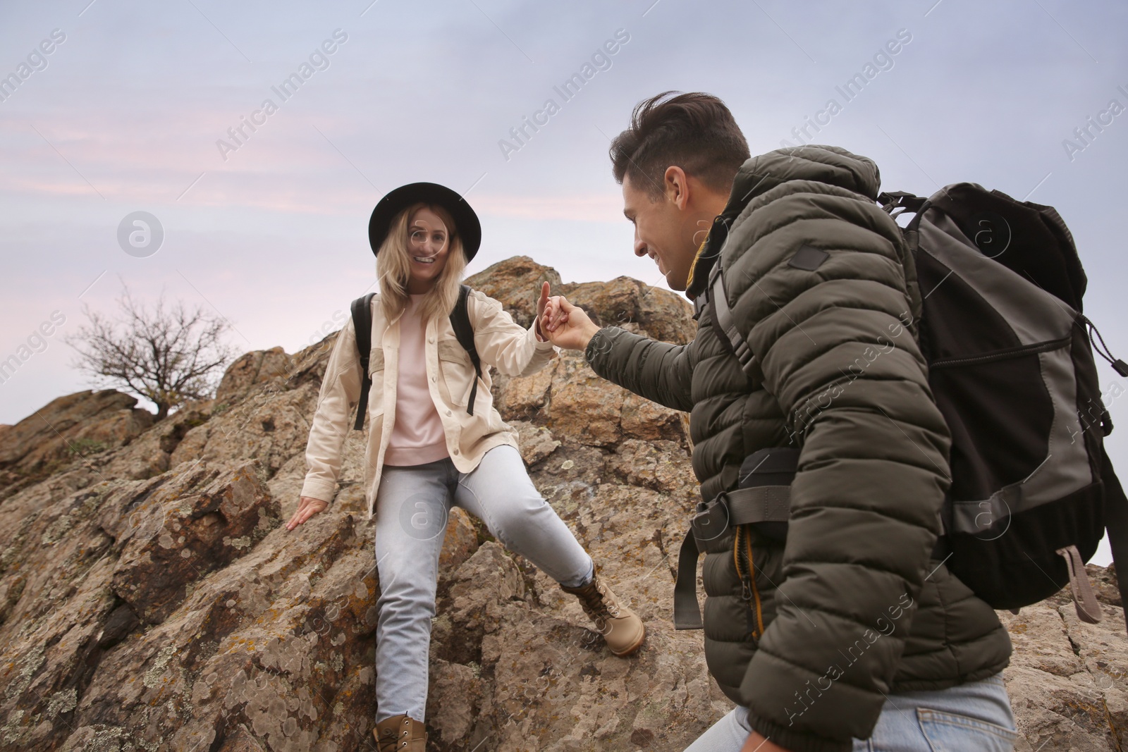 Photo of Couple of hikers with backpacks in mountains on autumn day