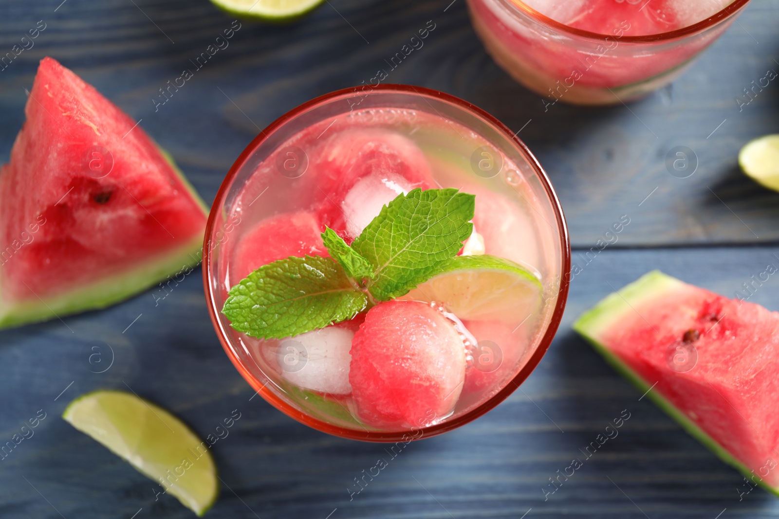 Photo of Glass of refreshing watermelon drink on blue wooden table, top view