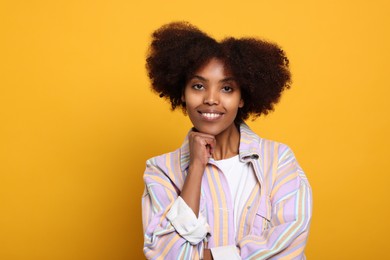 Photo of Portrait of smiling African American woman on orange background. Space for text