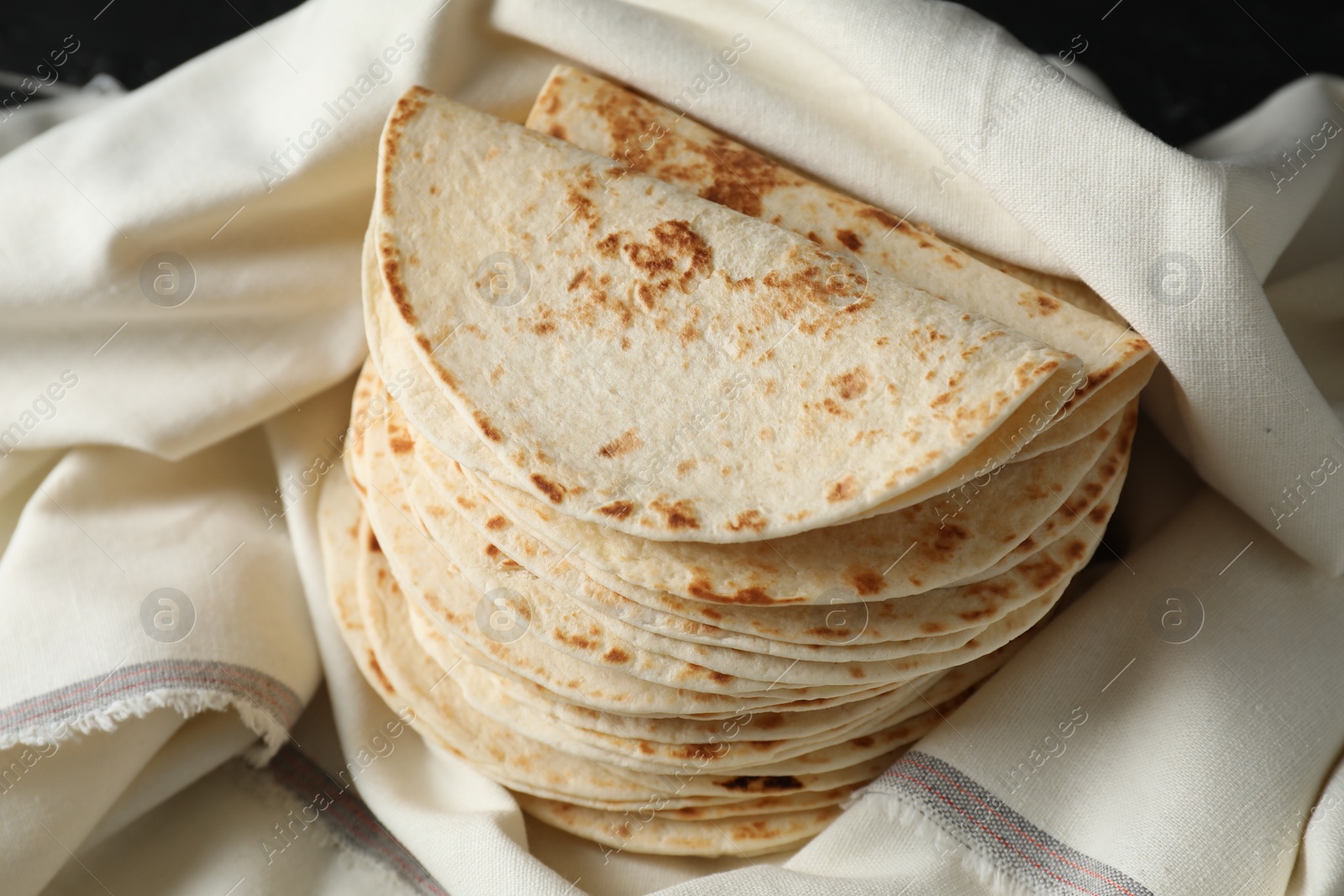 Photo of Stack of tasty homemade tortillas on table