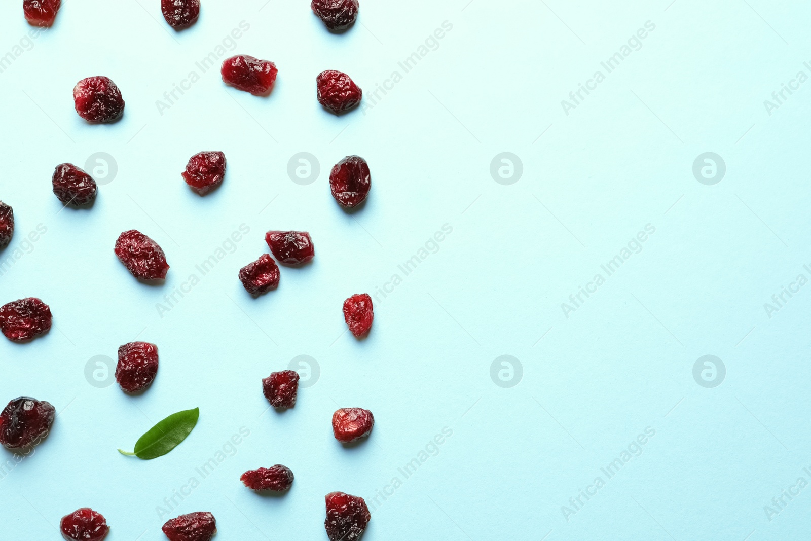 Photo of Flat lay composition of cranberries on color background, space for text. Dried fruit as healthy snack