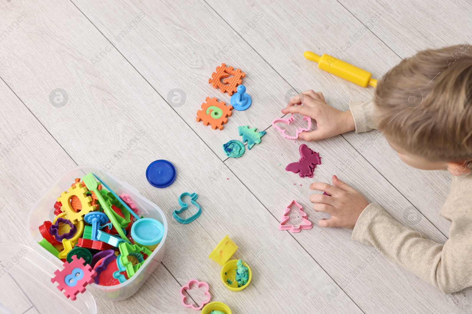 Photo of Cute little boy playing on warm floor indoors, above view. Heating system