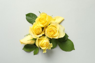 Photo of Beautiful yellow roses on light grey background, flat lay