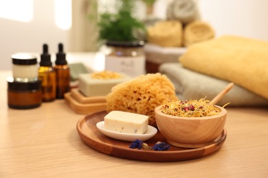 Dry flowers, loofah and soap bar on wooden table indoors. Spa time