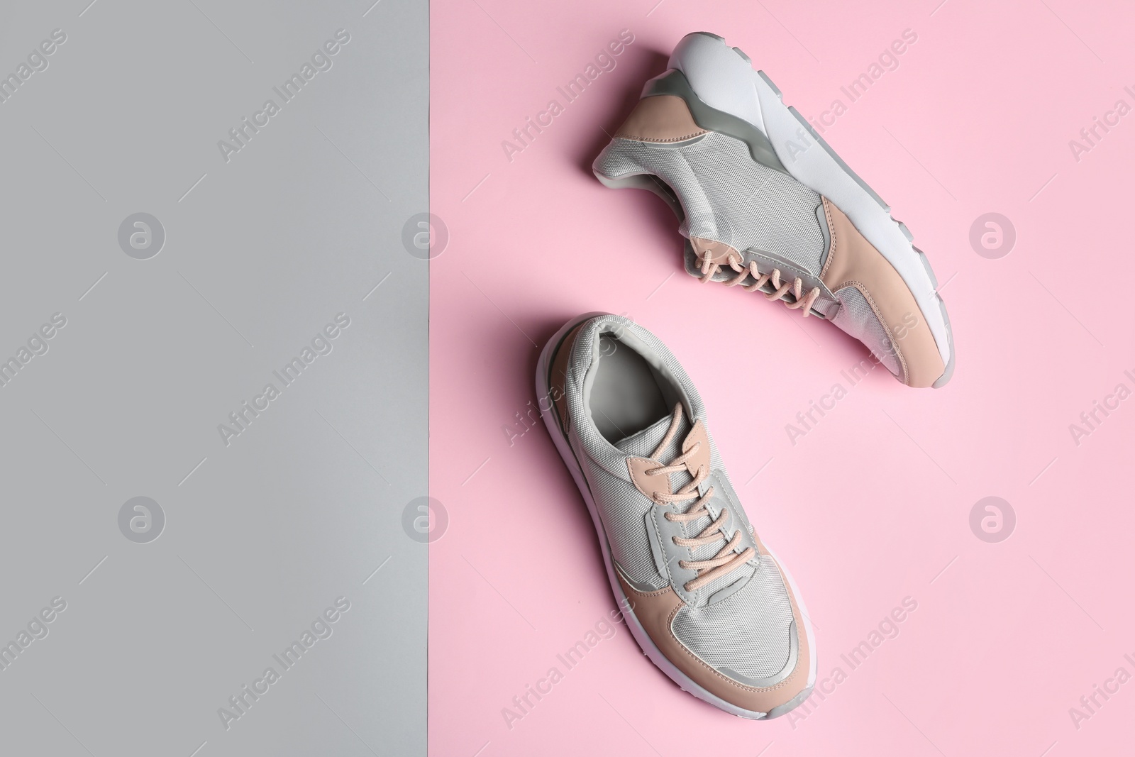 Photo of Pair of sports shoes on color background, top view. Space for text