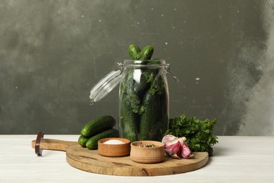 Photo of Pickling jar with fresh ripe cucumbers and spices on white wooden table