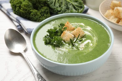 Photo of Tasty kale soup served on white wooden table, closeup