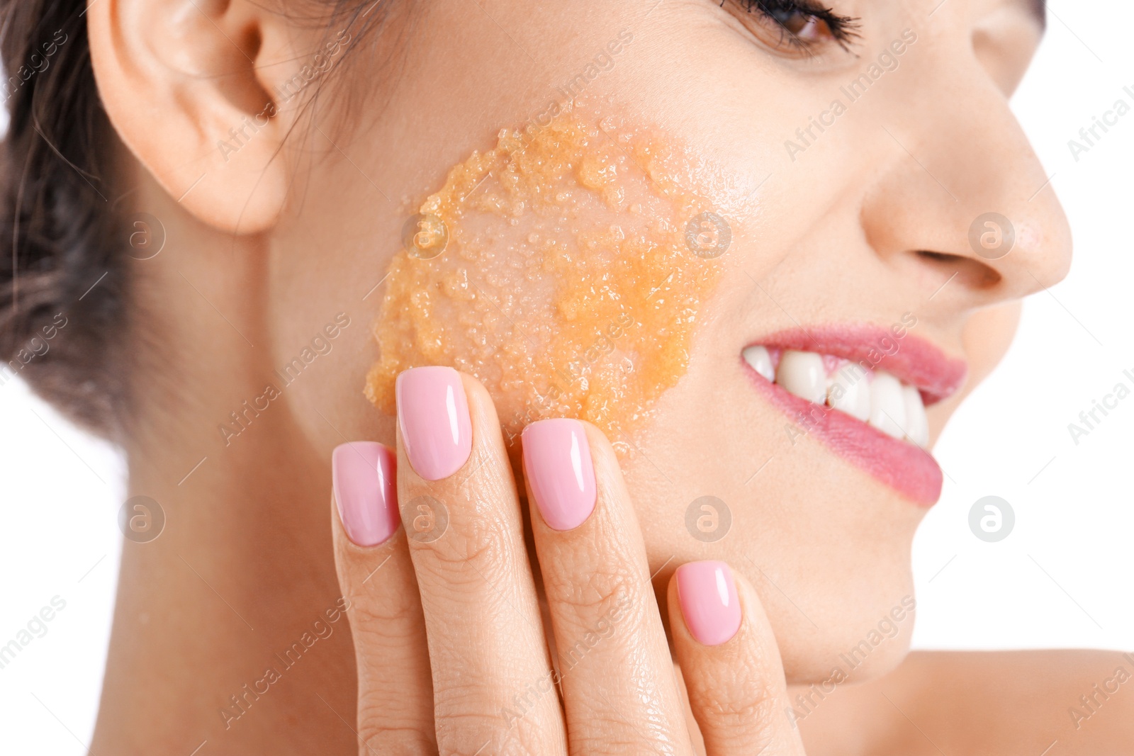 Photo of Young woman applying natural scrub on her face against white background, closeup