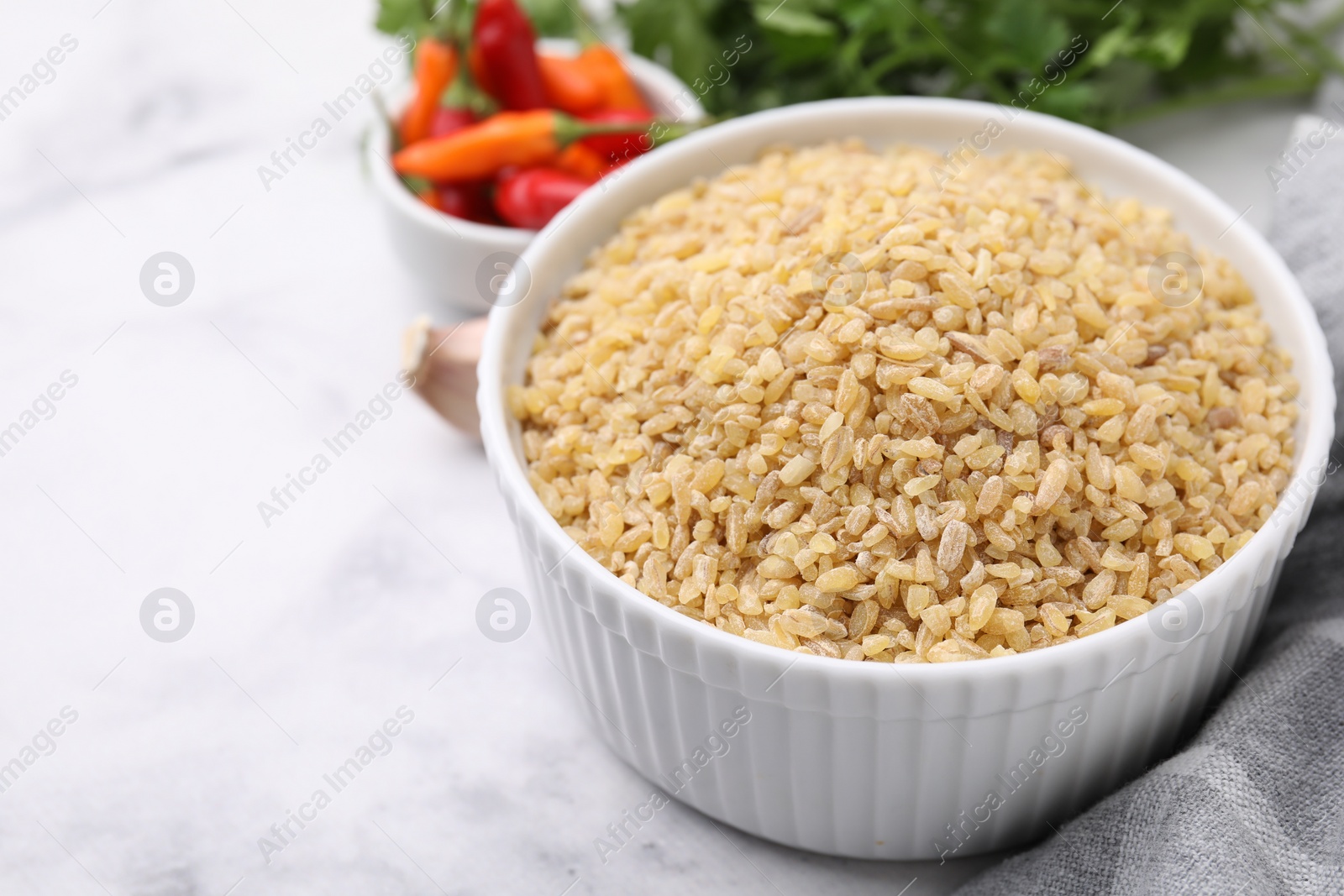 Photo of Raw bulgur in bowl on table, closeup