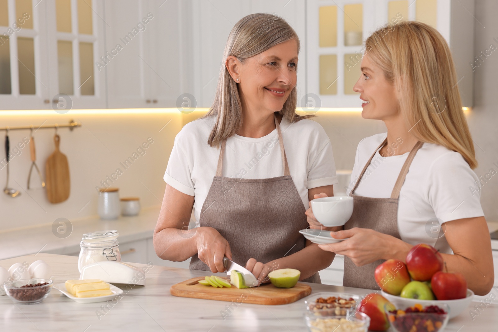 Photo of Happy mature mother with her daughter at kitchen