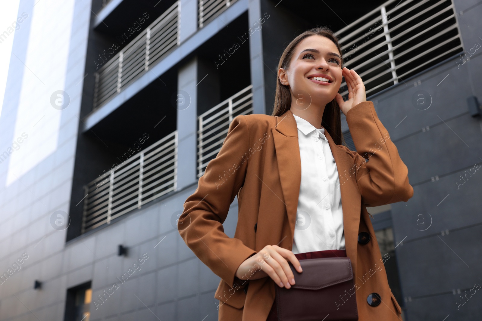 Photo of Young woman in formal clothes near building outdoors, space for text