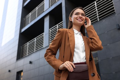 Photo of Young woman in formal clothes near building outdoors, space for text