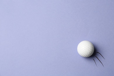 Photo of Golf ball flying on lilac background - creative image. Top view