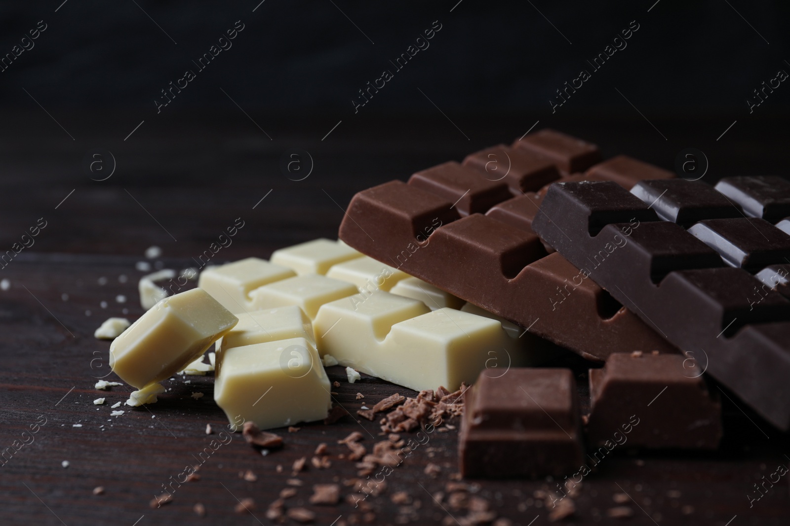 Photo of Different tasty chocolate bars on wooden table