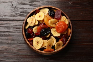 Photo of Mix of delicious dried fruits on wooden table, top view