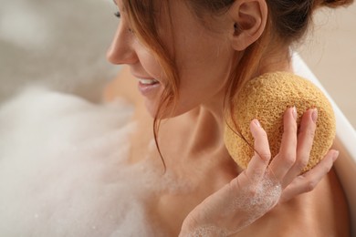 Photo of Woman rubbing neck with sponge while taking bath, closeup