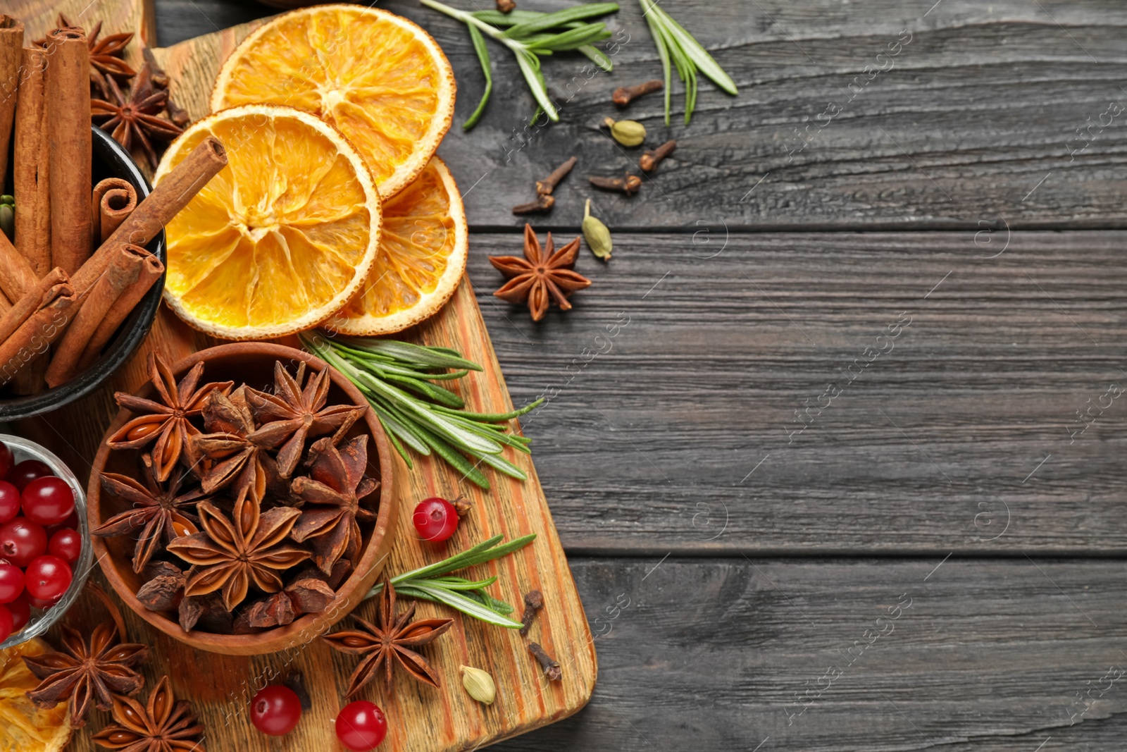 Photo of Flat lay composition with mulled wine ingredients on black wooden table. Space for text