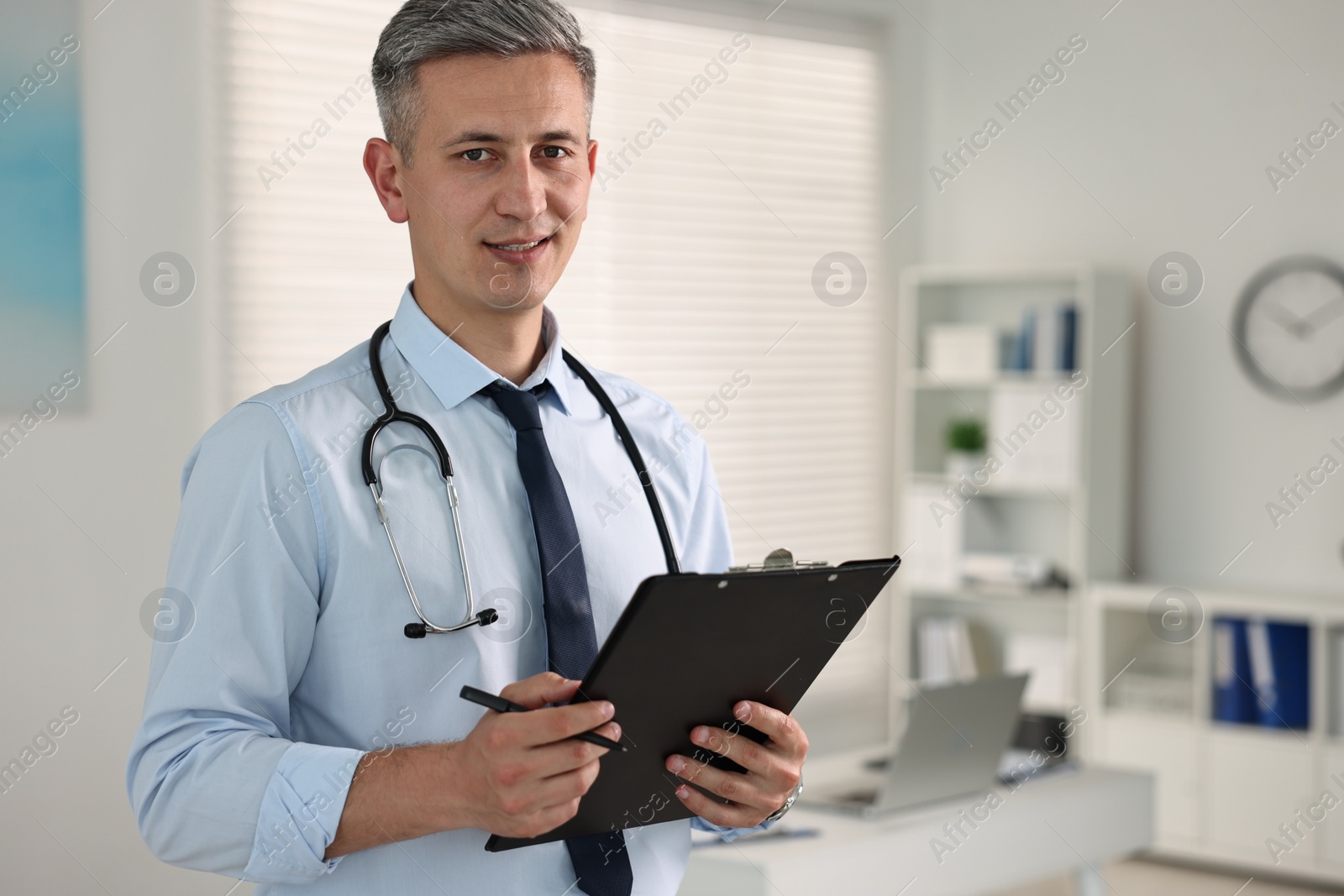 Photo of Doctor with stethoscope and clipboard in clinic, space for text