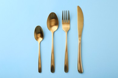 Photo of Stylish cutlery set on light blue table, flat lay