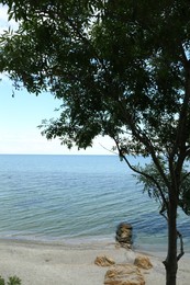 Photo of Picturesque view of sandy beach and stones near sea