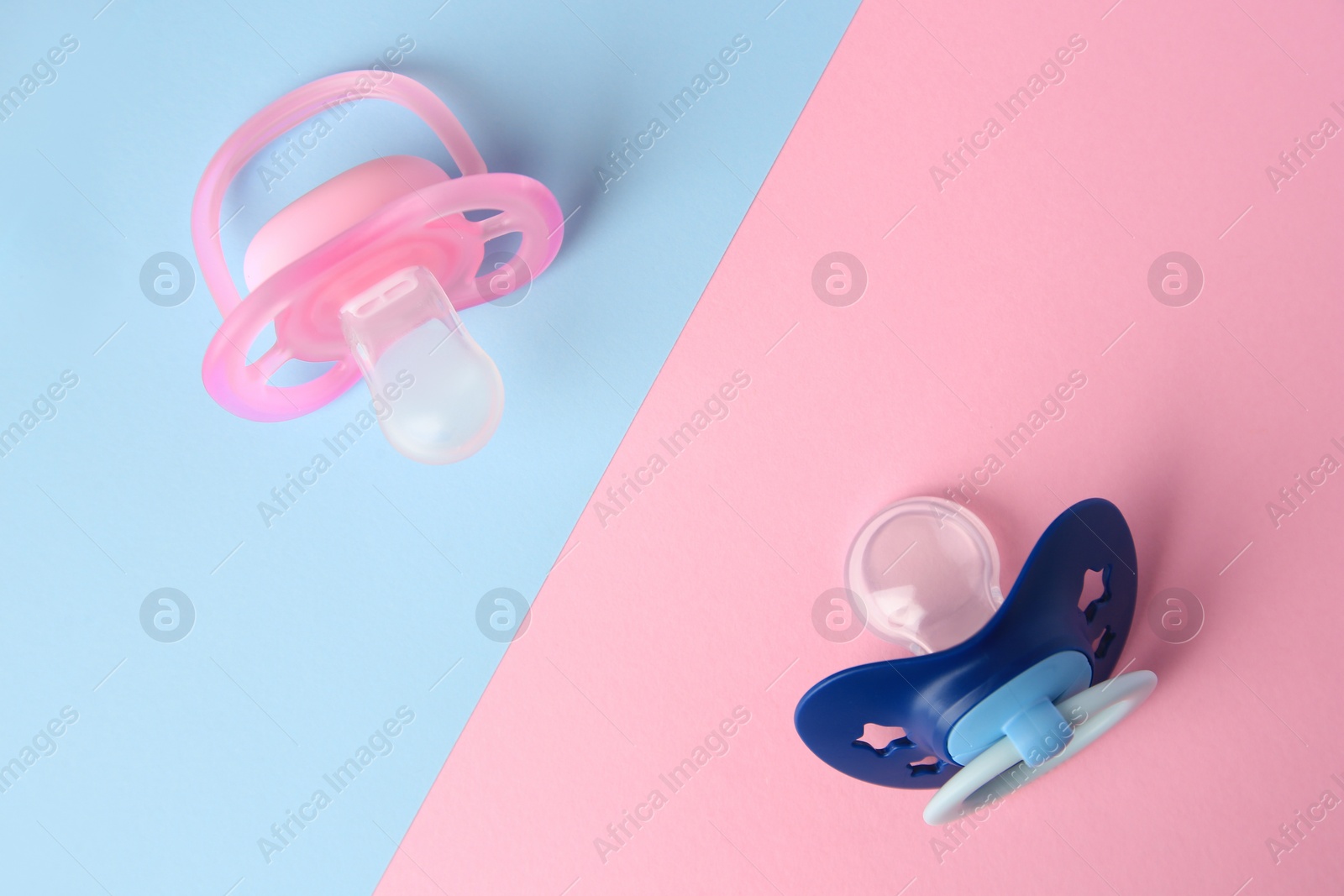 Photo of Baby pacifiers on color background, flat lay