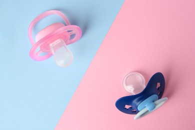 Photo of Baby pacifiers on color background, flat lay