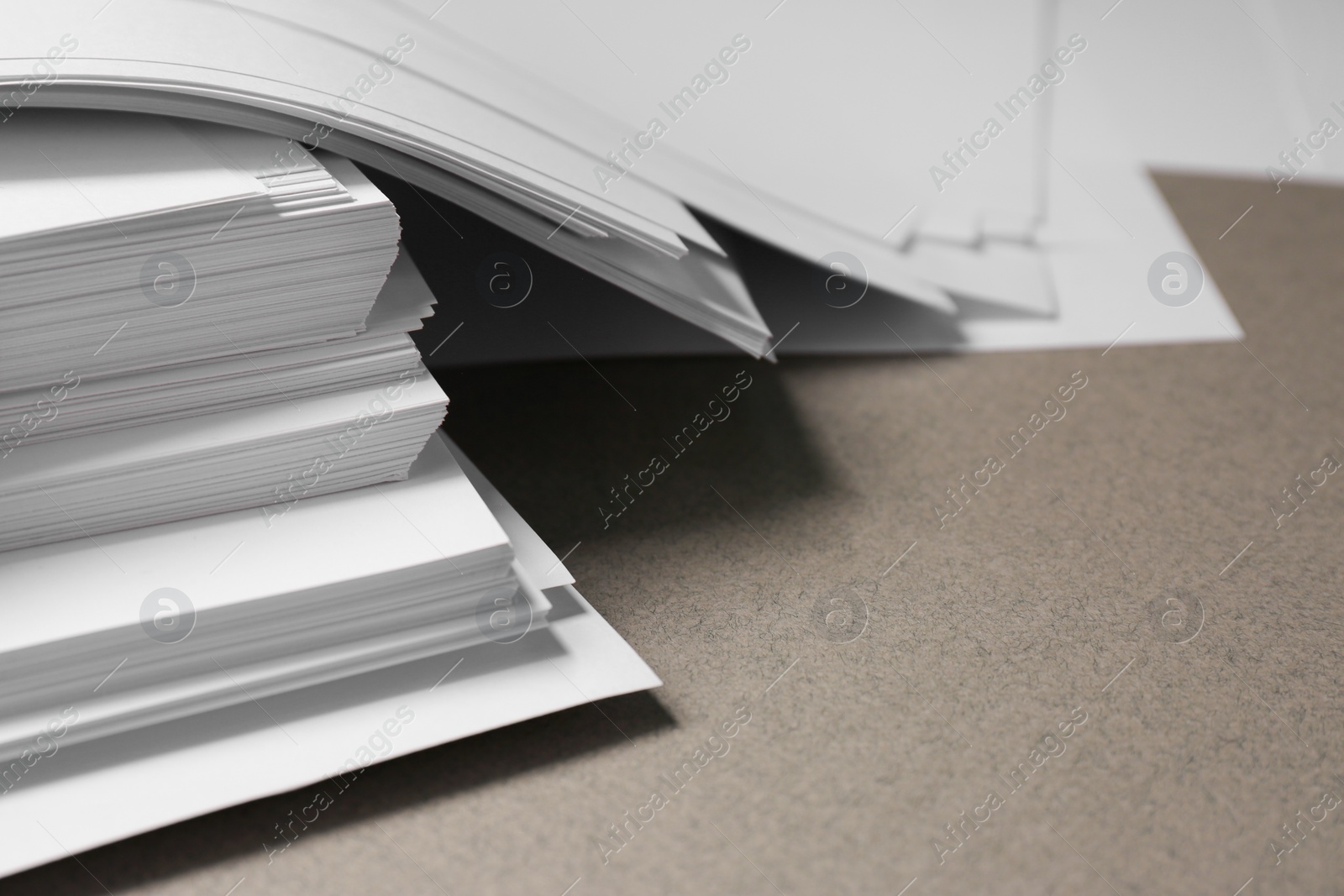 Photo of Pile of paper sheets on grey background, closeup. Space for text