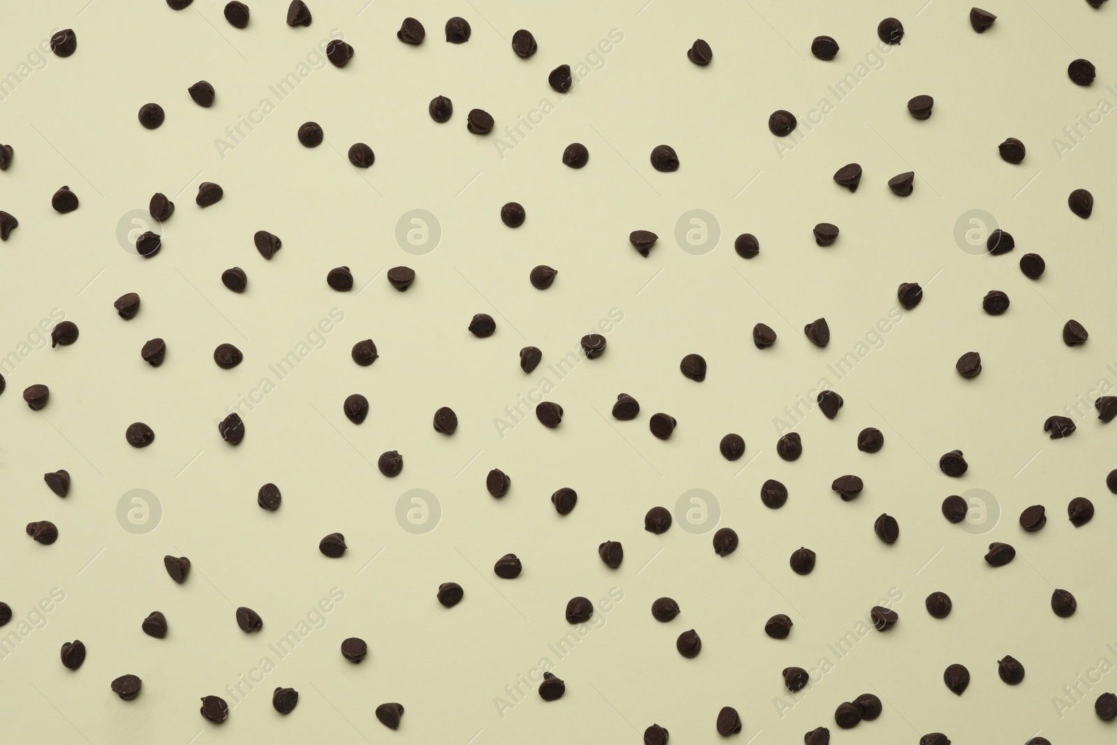 Photo of Delicious chocolate chips on beige background, top view