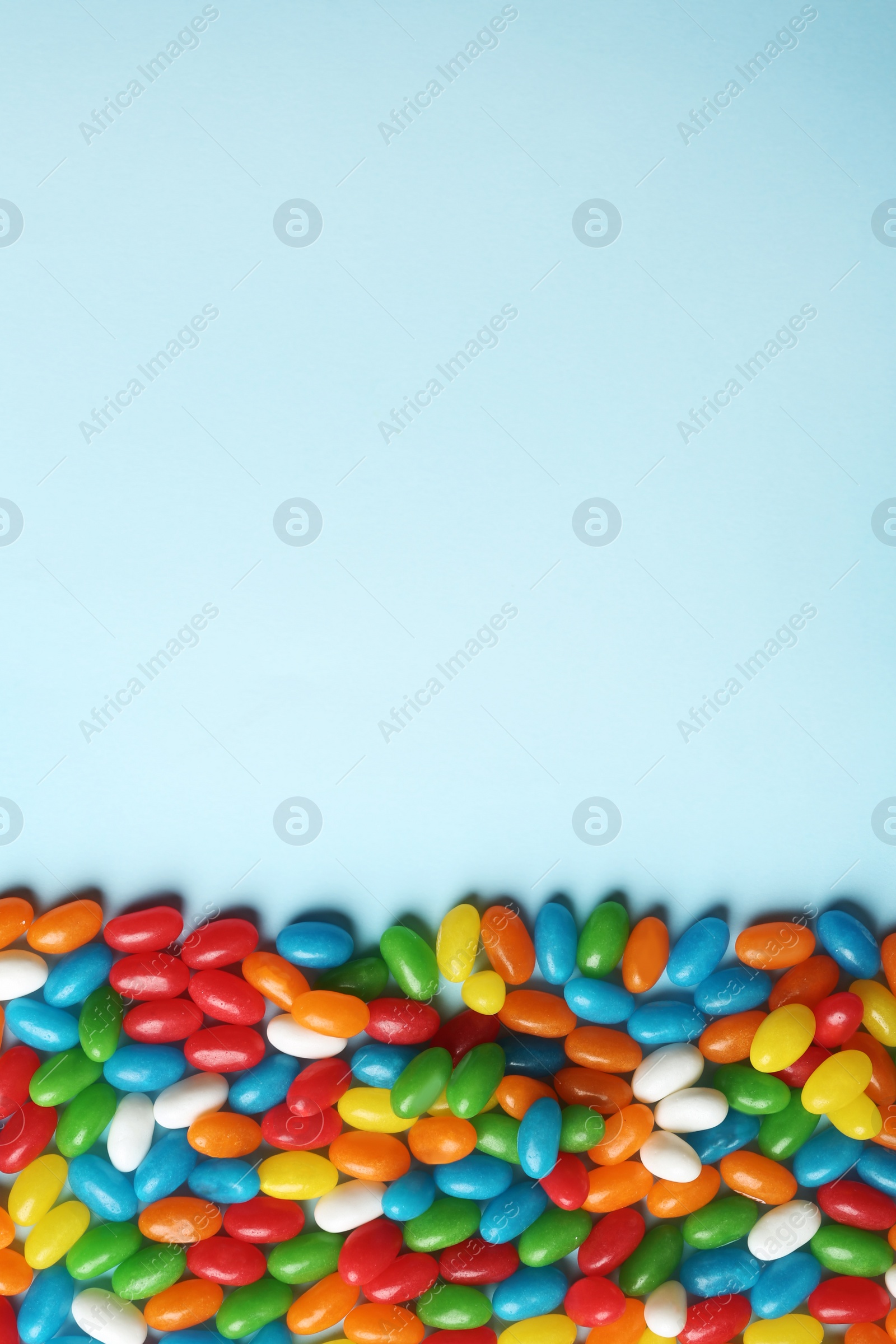 Photo of Flat lay composition with delicious jelly beans on color background. Space for text