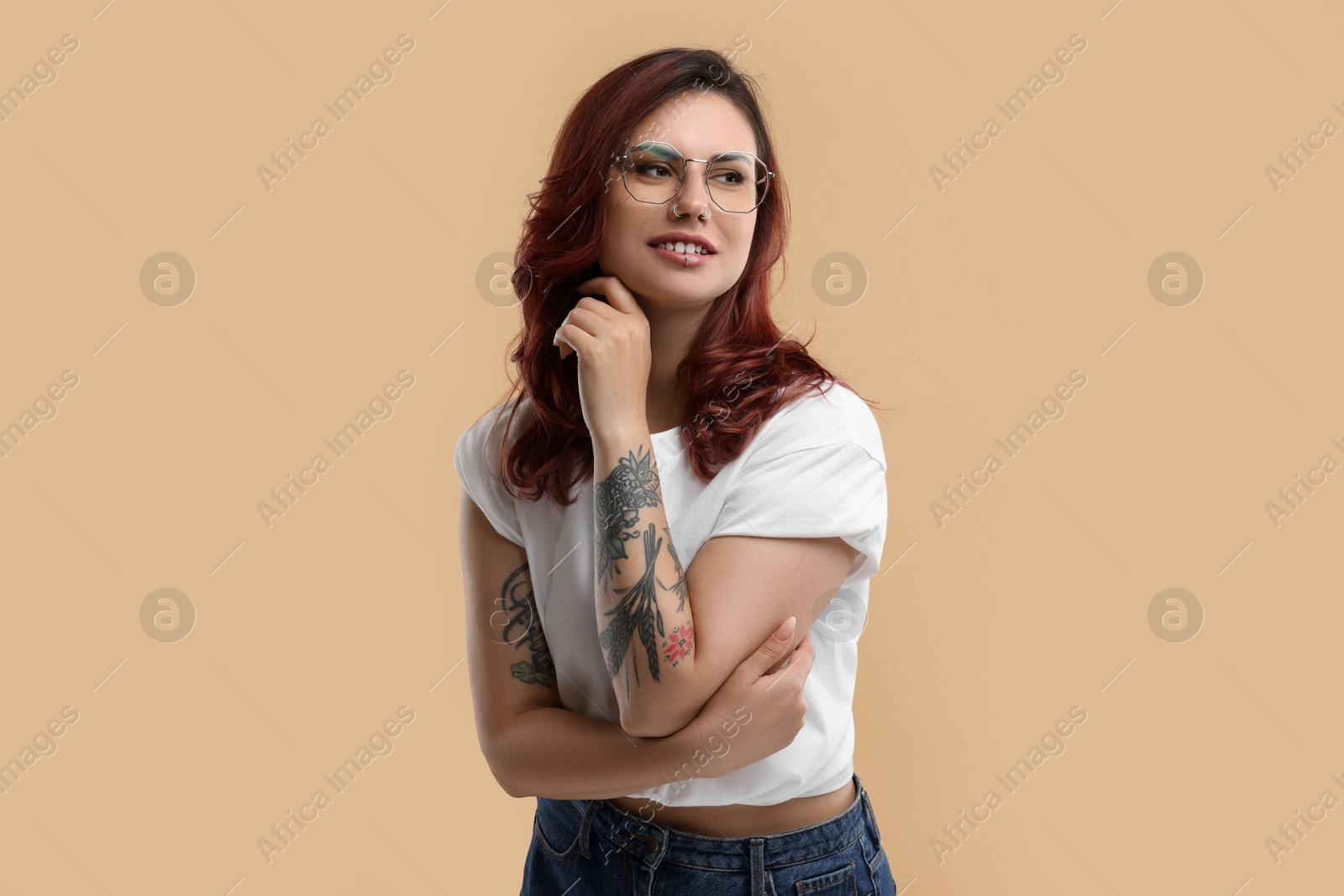 Photo of Portrait of beautiful tattooed woman on beige background