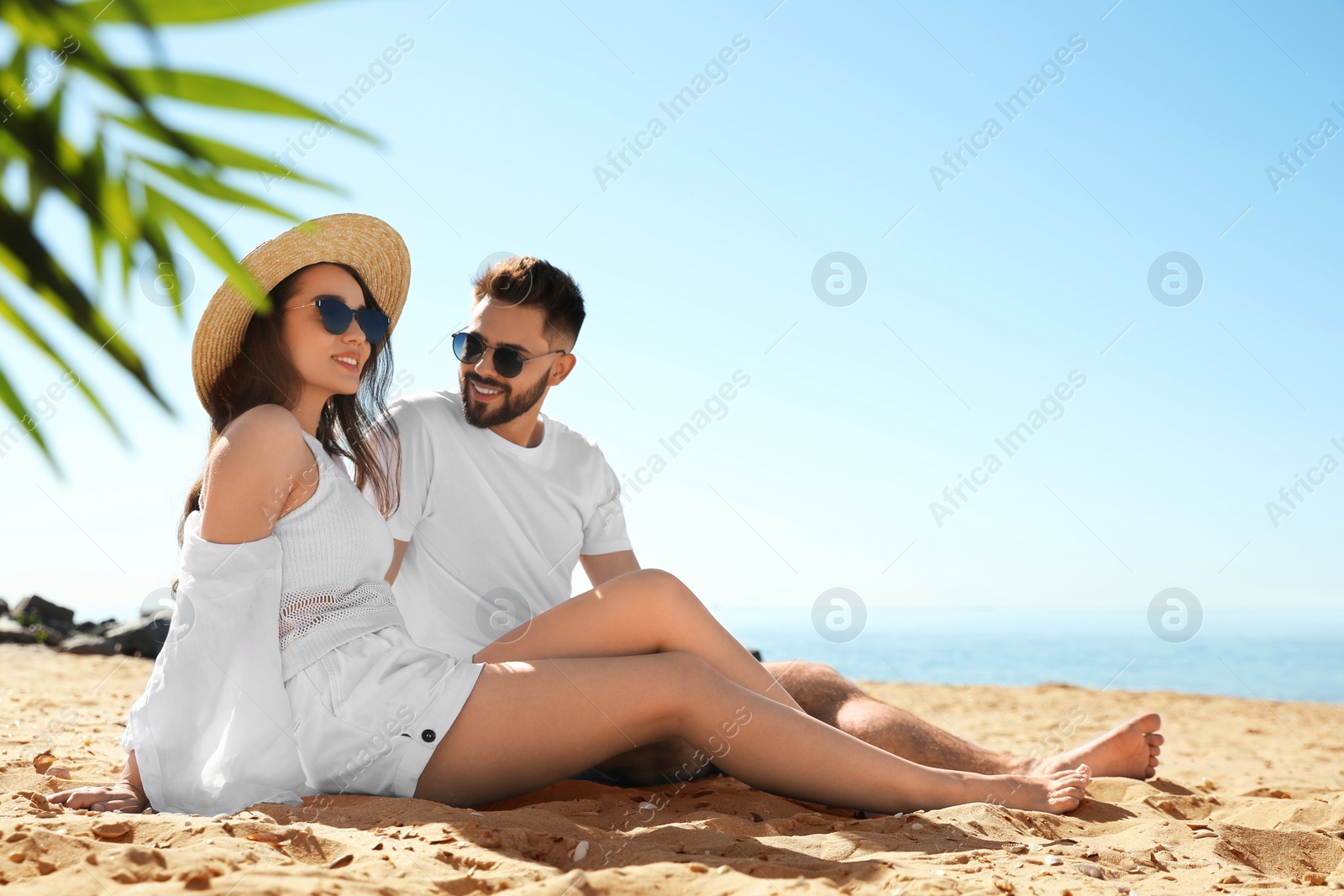 Photo of Happy young couple on beach near sea. Honeymoon trip