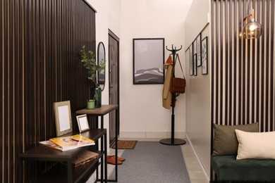 Modern hallway interior with stylish furniture and paintings