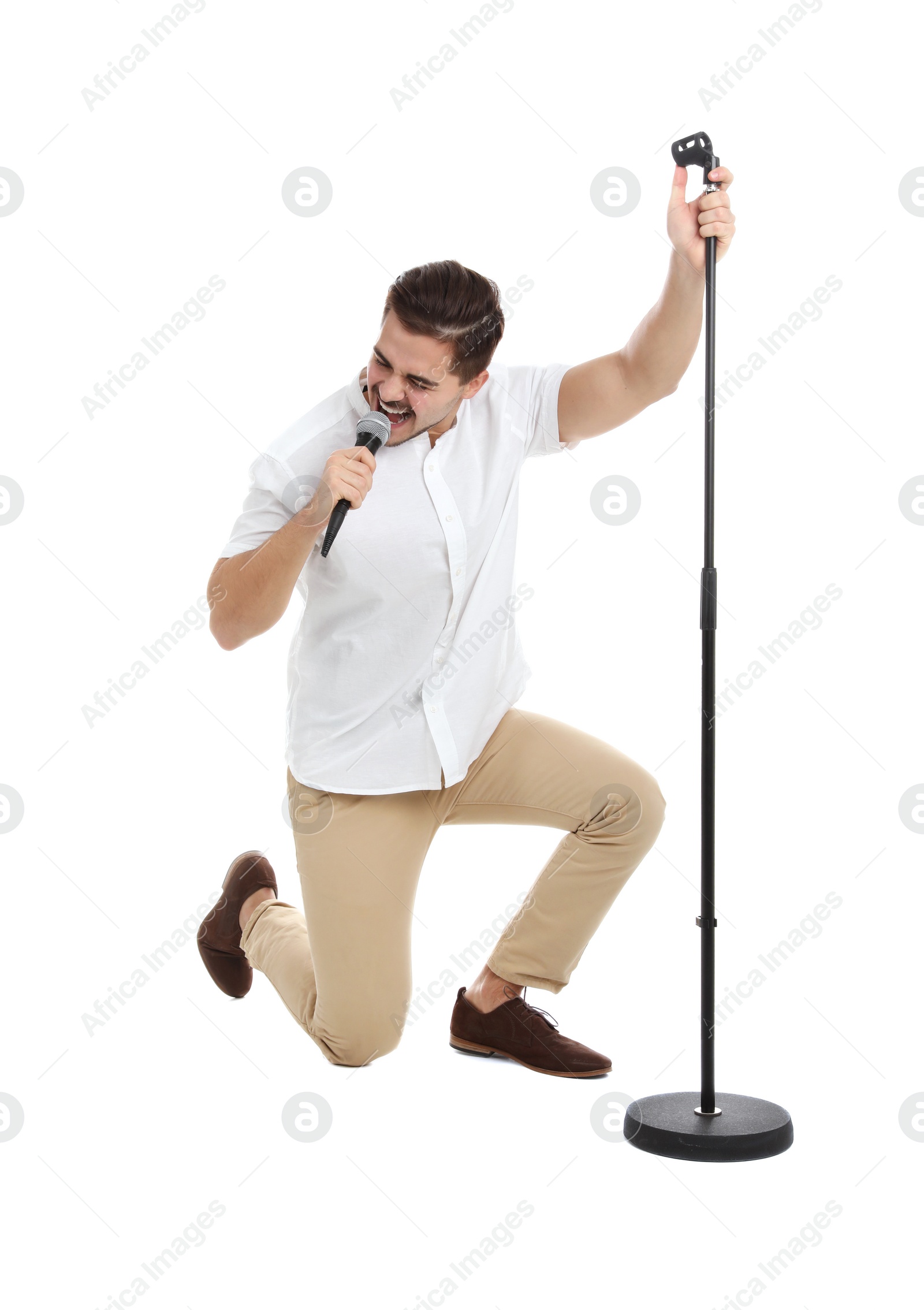 Photo of Young handsome man singing in microphone on white background