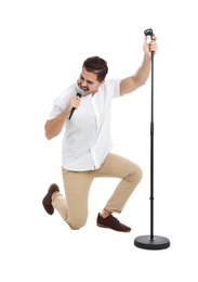 Young handsome man singing in microphone on white background