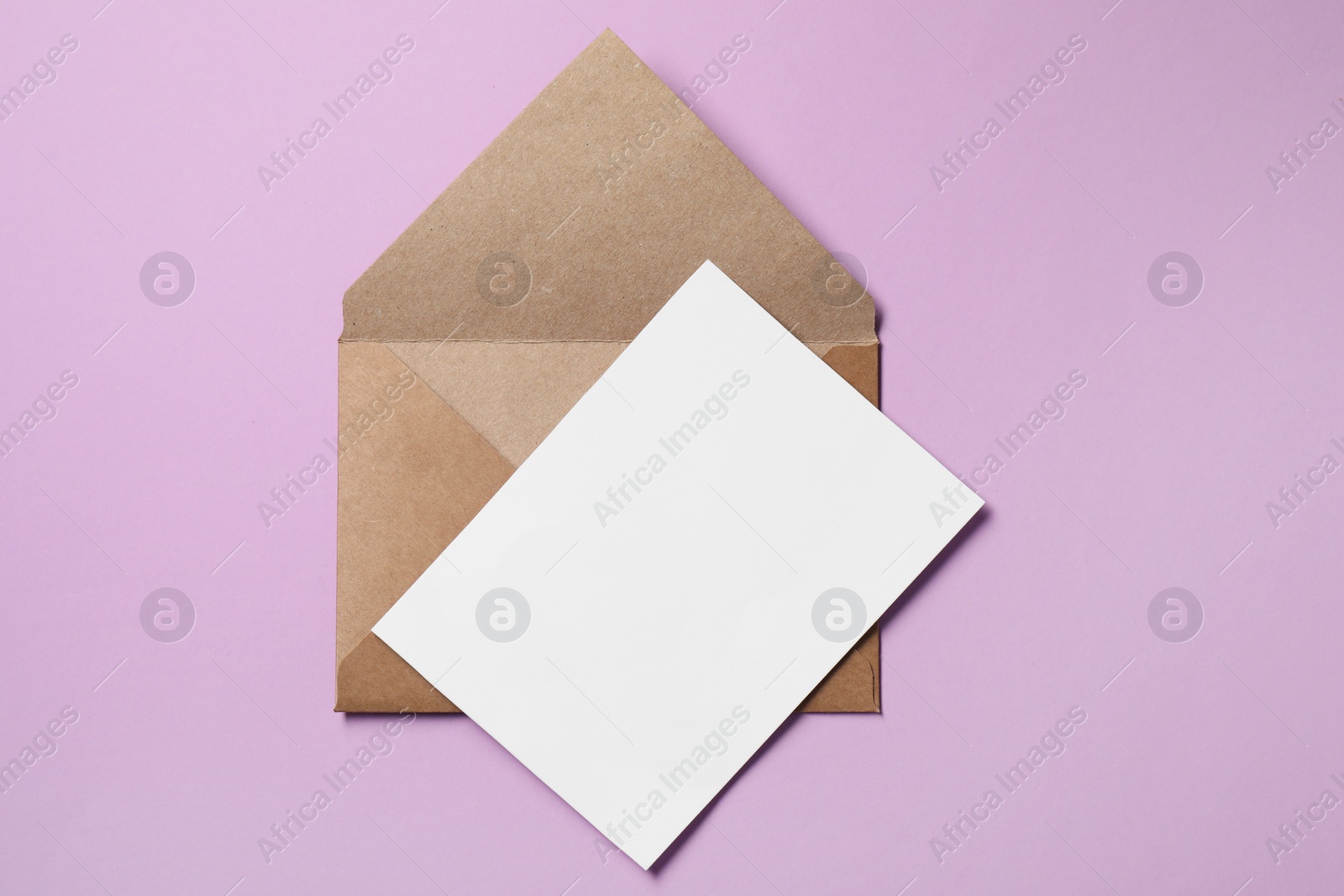 Photo of Letter envelope and card on violet background, top view. Space for text